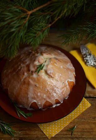 Lemon pie with rosemary and lime icing on the big plate under the fir branches