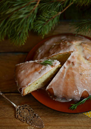 Lemon pie with rosemary and lime icing on the big plate under the fir branches