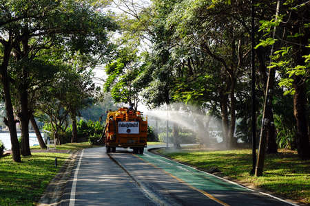 January 28,2016 : Watering the lawn on road by water tanker truck at Somdet-yah park Bangkok, Thailand.のeditorial素材