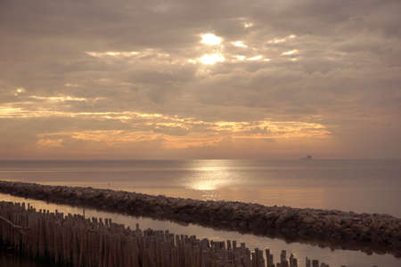 Long simple wooden jetty leading into blue ocean in the gulf of Thailand with sunrise (Retro tone style)の写真素材