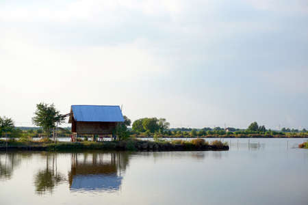 Landscape lake with cottage house village. relaxation waterfront hut in countrysideの写真素材