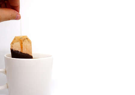 tea bag in white cup on white backgroundの写真素材