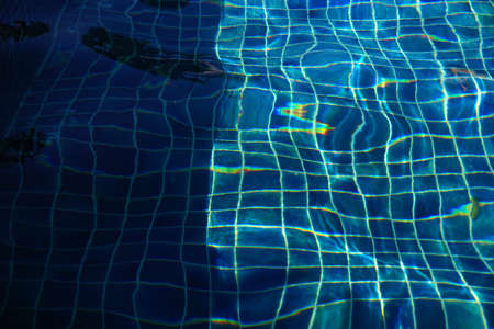 Blue pool water with sun reflections backgroundの写真素材