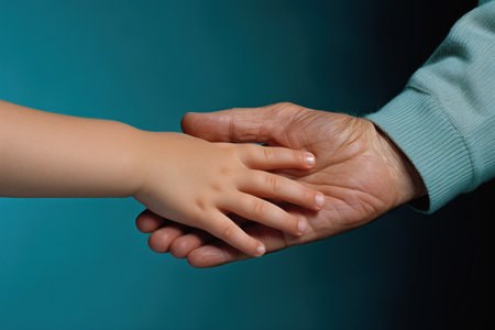 Grandmother and grandson holding hands on a blue background, closeupの素材