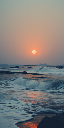 Beautiful sunset over the sea with waves on the sandy beach.の素材