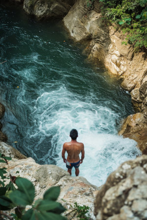 Man Standing on Top of Rock by River, Enjoying Natures Beautyの素材