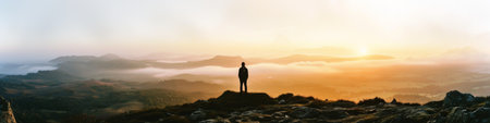 Person Standing on Top of Mountain at Sunsetの素材