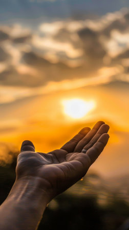 Silhouette of hand with sunrise background, soft focus and vintage toneの素材