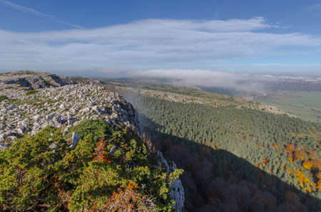 Autumnal forest at the foot of the rocky summitの写真素材