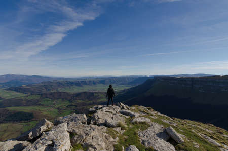 green valley from the rocky top of the mount with a model in the center enjoying freedomの写真素材