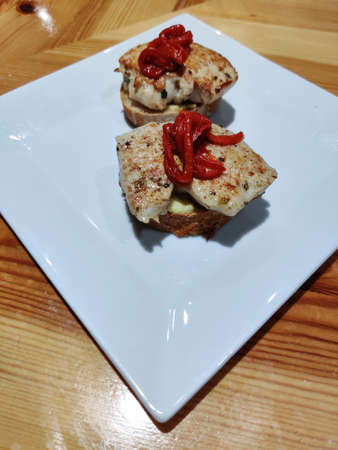 meat top on bread and red pepper on plateの写真素材