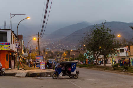 Lima, Peru, July 12, 2014:  Collique neighborhood at sunset with motorcycle car, people walking and poor houses in the backgroundのeditorial素材
