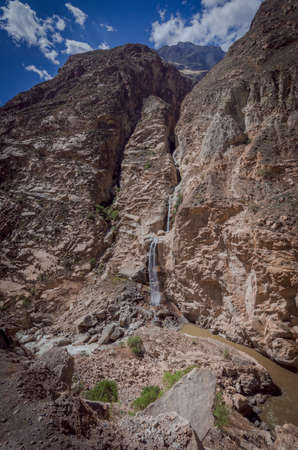 cascades of water flowing from large cracks of rock walls to the river in the canyon of the duck in peruの写真素材