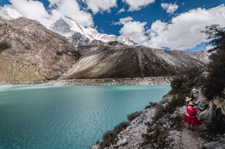 Ancash, Peru, July 29, 2014: two peruvian women in typical dress on a path, in the turquoise lagoon of paron between snowy mountain peaks in the andesのeditorial素材