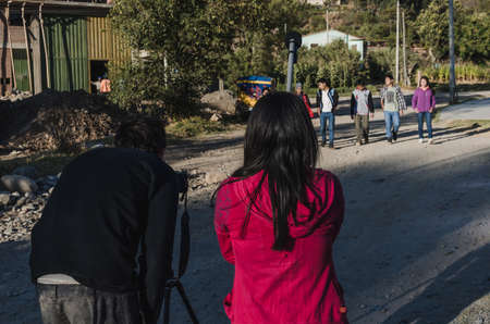 Yungay, Peru, August 5, 2014: woman and man with their backs to the camera recording a group of humble young people acting for a home short filmのeditorial素材