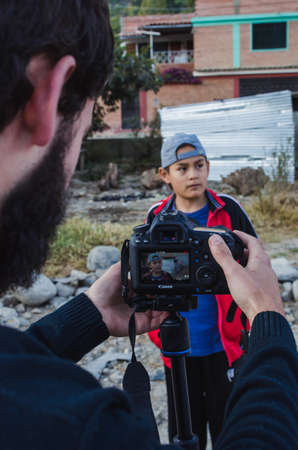 Yungay, Peru, August 5, 2014: Portrait of bearded man recording a homemade short film with a camera to Latino teenage boyのeditorial素材