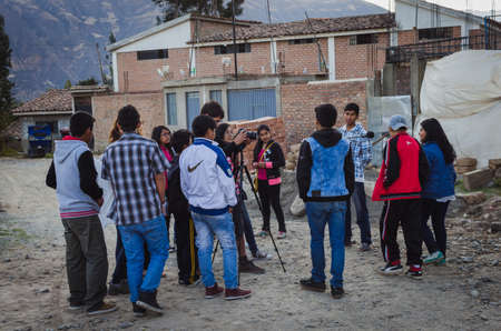 Yungay, Peru, August 5, 2014: NGO cooperators teaching short films workshop to a group of humble teenagers and recording with camera and microphone in neighborhoodのeditorial素材