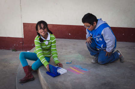 Yungay, Peru, August 8, 2014: smiling girl and boy playing tic tac toe resting on the floor where they have painted with chalkのeditorial素材
