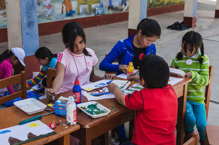 Yungay, Peru, August 8, 2014: group of girls and boy sitting at a table doing crafts with paint and brushes at schoolのeditorial素材