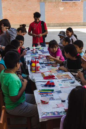 Yungay, Peru, August 4, 2014: Humble boys and girls around a table doing crafts with paint, paper, and glue accompanied by adults, 
verticallyのeditorial素材
