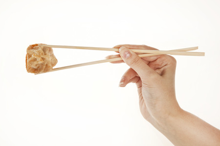 Hand holding Chinese Dumpling Wonton with chopsticks, isolated on whiteの写真素材