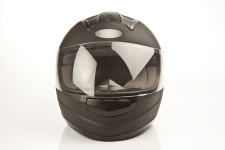 Studio image of a black motorcycle helmet with the visor closed on a white backgroundの写真素材