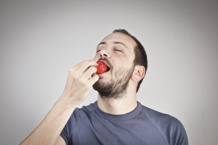 Man eats strawberryの写真素材