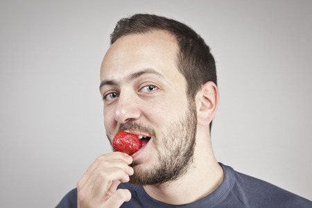 Man eats strawberryの写真素材