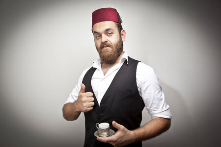Man in traditional turkish hat and dress kabadayi with turkish coffeeの写真素材