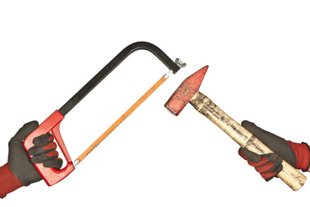 Two hand hold hammer and hacksaw on a white backgroundの写真素材
