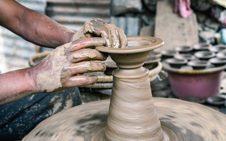 Potter working on a pottery wheel, shallow depth of field