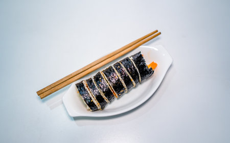 Sushi roll japanese food on a white plate with chopsticksの写真素材