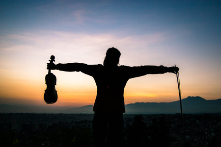 Silhouette of woman playing violin on the background of Sunrise in Kathmandu, Nepal.の写真素材