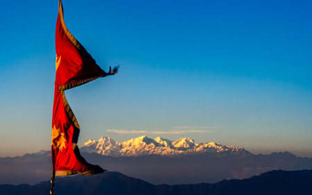 Waving flag on top of Himalayan mountain at sunset, Nepal