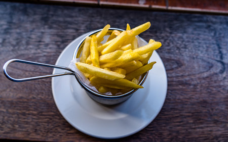 French fries in a bowl on a wooden table. Selective focus.の写真素材