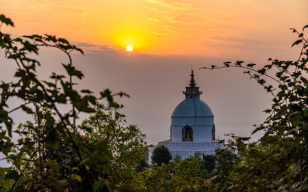 Silhouette of Buddhist world peace pagoda stupa at sunset in Pokhara, Nepalの写真素材
