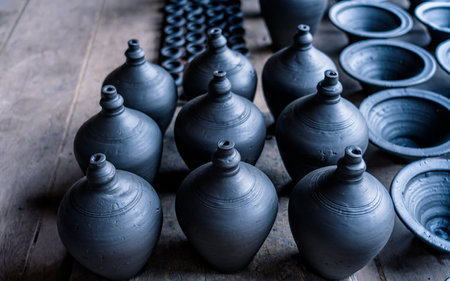 Clay vases on a wooden table in a pottery workshop