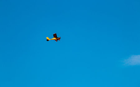 Small airplane flying in the blue sky. The concept of freedom and travel.