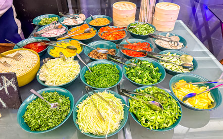 Variety of vegetable salads in bowls at a market in Thailand.の写真素材