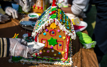 Close-up of a gingerbread house being decorated for Christmas.