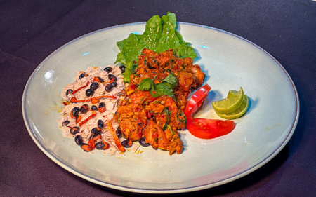 Asian dish of fried fish with curry sauce on white plateの写真素材