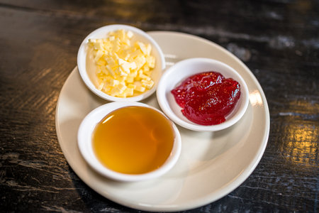 A set of different sauces on a plate on a wooden table.