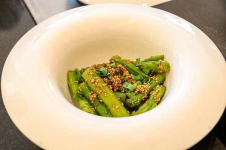 Stir fried green beans with garlic and sesame in white bowl