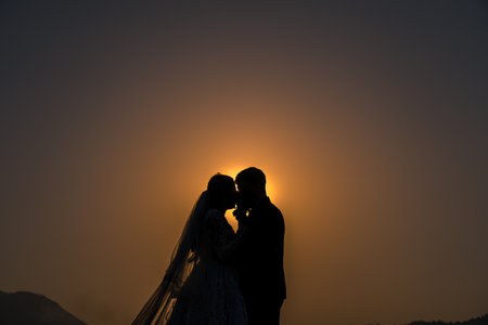 Silhouette of a couple on the background of the rising Sun.の写真素材