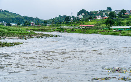 Landscape view of river, with surrounding greenery and a backdrop of buildings.の写真素材