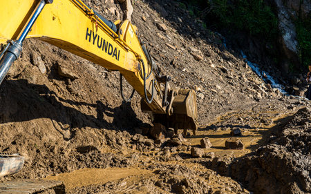 Yellow excavator working on the construction of a new road in the mountainsの写真素材
