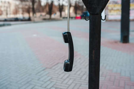 Handset hangs on the street on a wireの写真素材