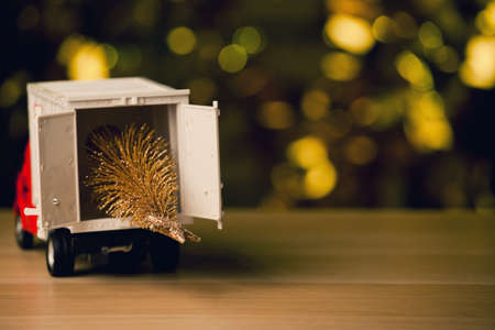 red toy car miniature tree wooden table gold bokehの写真素材