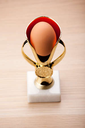 egg gold cup wooden table nobody