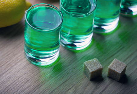 absinthe shot glass sugar lemon wooden tableの写真素材